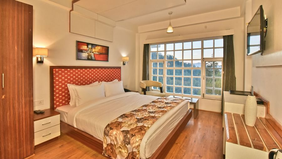 Bedroom with a wooden wardrobe next to it at DLS Hillcrest Resort, Shimla.